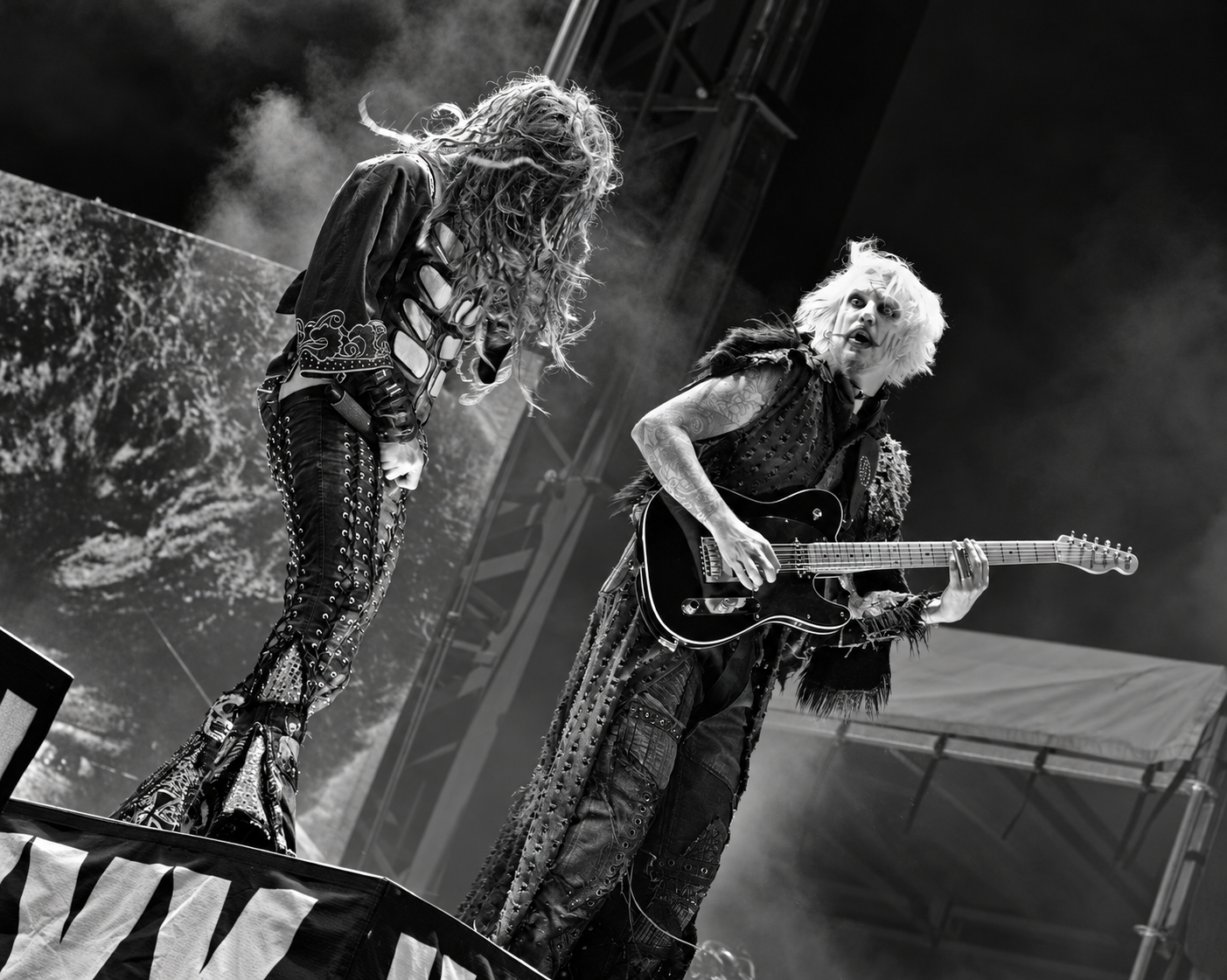 John 5 playing guitar alongside Rob Zombie onstage, black-and-white photograph